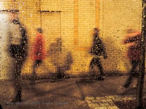 People walking on Meeting Street in the rain.